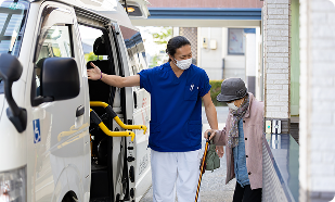 福祉車両で高齢者の乗降を介助するスタッフ