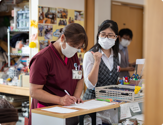 利用者と一緒に作業するスタッフ